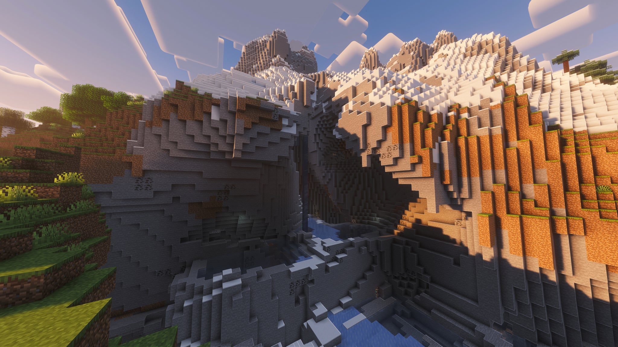 A landscape screenshot of a Minecraft seed, showing a large surface cave system built into the side of a large snow-topped mountain. - 50