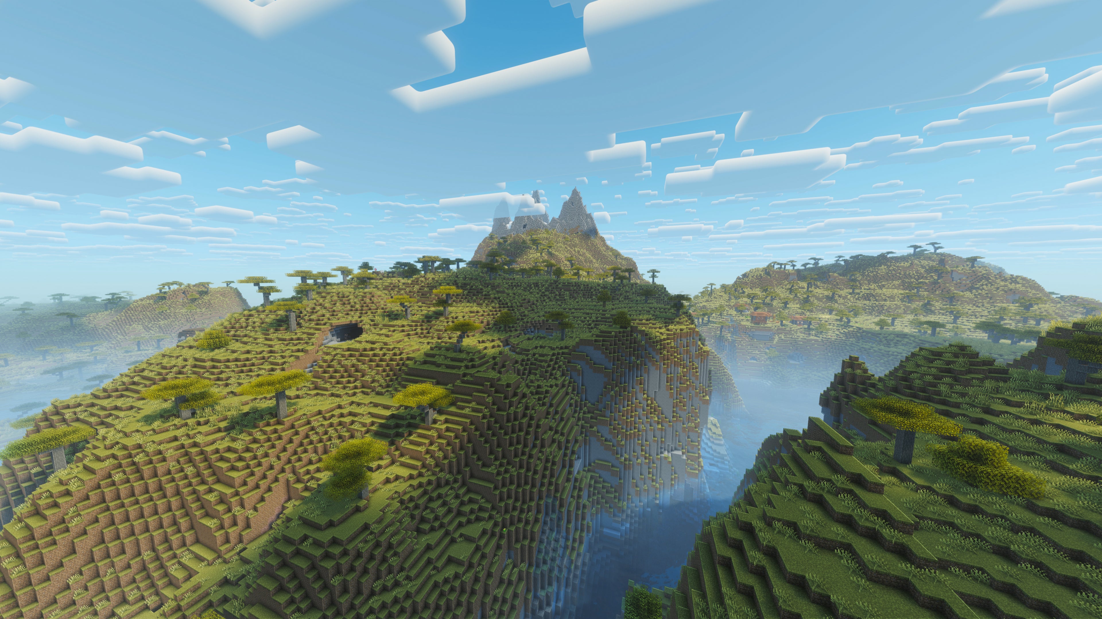 A landscape screenshot of a Minecraft seed, showing a large hilly plains biome with plenty of valleys and a large mountain in the distance. - 24