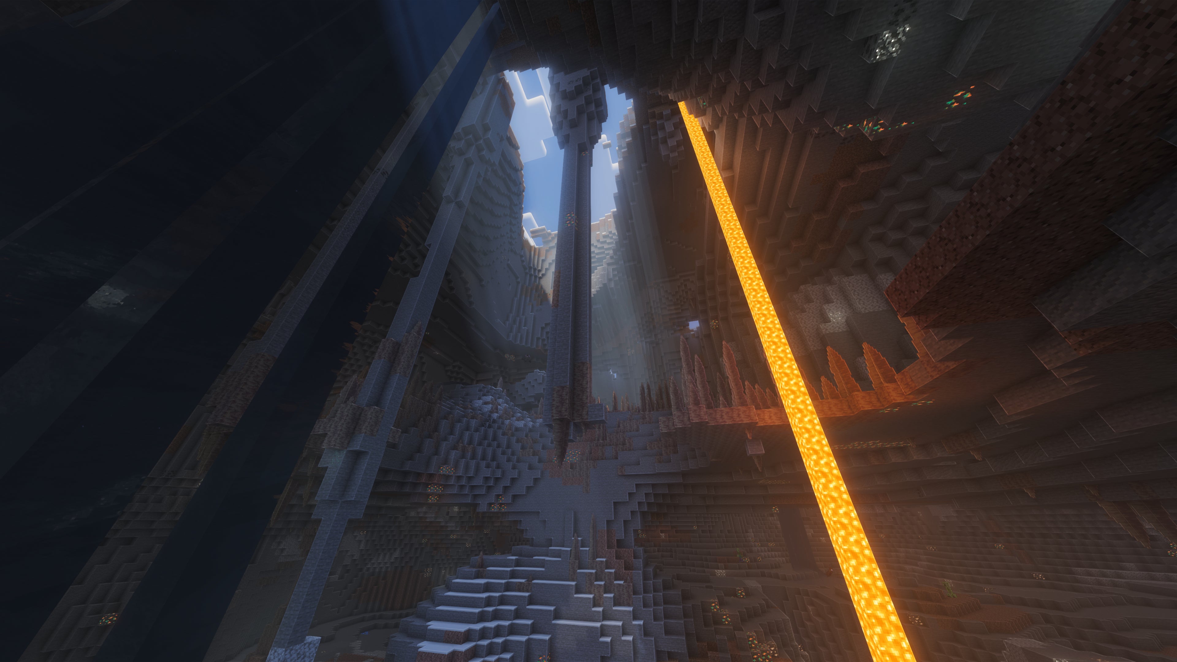 A landscape screenshot of a Minecraft seed, showing a view from the bottom of a cave system up towards the sky, where sunlight is spilling through. - 32