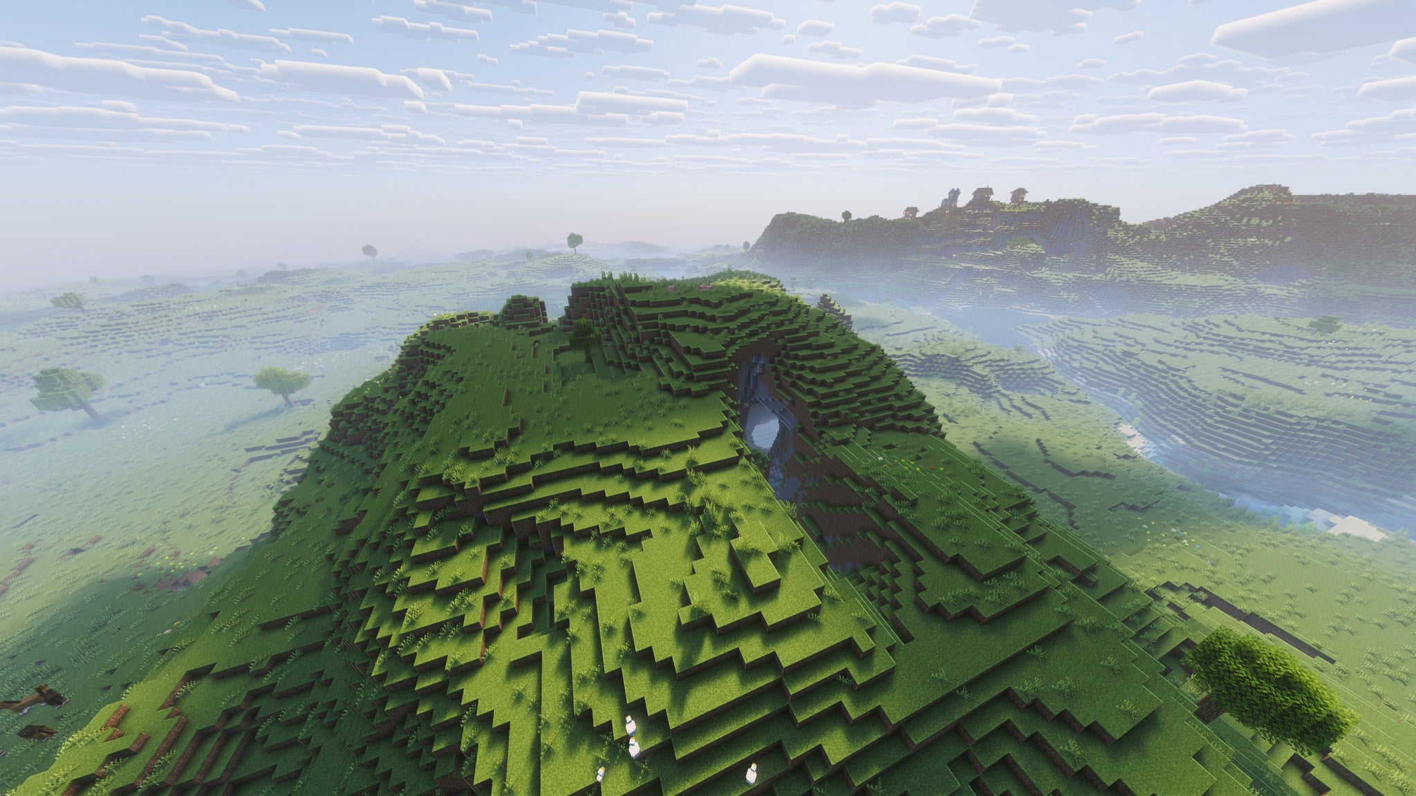 A landscape screenshot of a Minecraft seed, showing a plains hill with an open cave system leading into the depths below. - 48