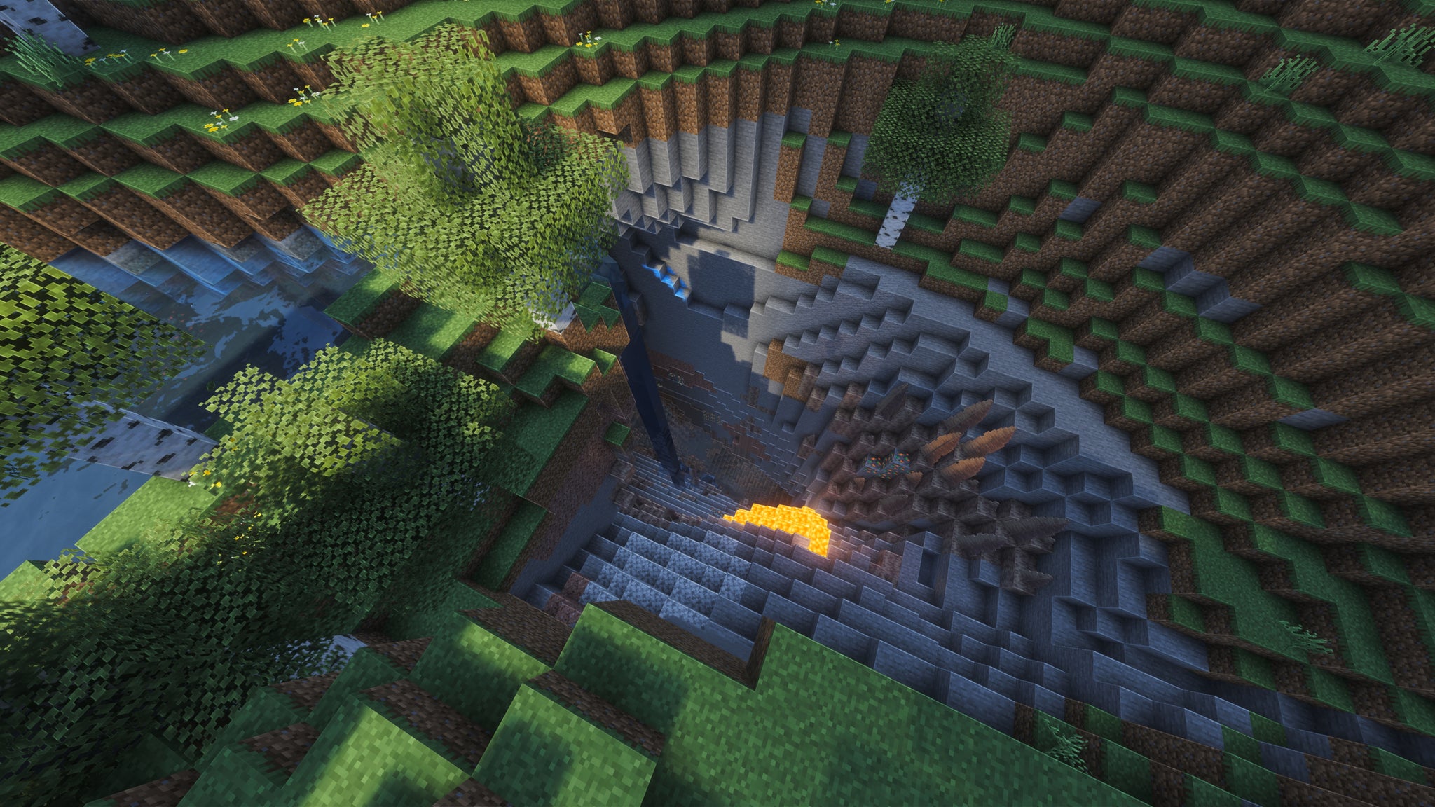 A landscape screenshot of a Minecraft seed, showing a ravine in the ground leading down into a cave below, with both water and lava spilling down the ravine. - 14