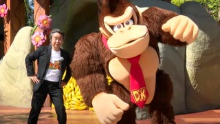 Nintendo's Shigeru Miyamoto strikes a pose with a Donkey Kong park mascot at Universal Studios Japan's new Donkey Kong Country expansion.