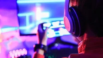 Stock image of a person playing games on their mobile phone