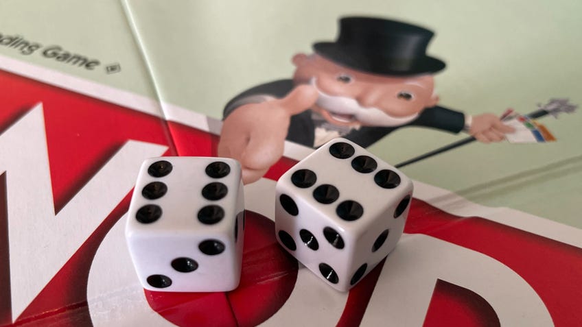 Two dice placed in the centre of the Monopoly board after a double has been rolled, with both dice showing six.