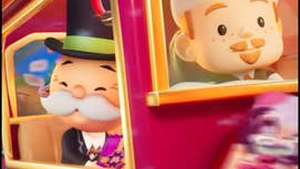 The Monopoly Man riding on a Christmas-themed train while holding a pack of stickers.