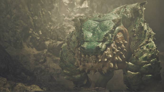 A Chatacabra, a large monster in Monster Hunter Wilds, lumbers towards the camera inside a cave.