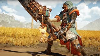 A Monster Hunter Wilds screenshot showing the exclusive open beta pendant hanging from a Hunter's sword. It resembles a fluffy toy version of a cat-like Palico.