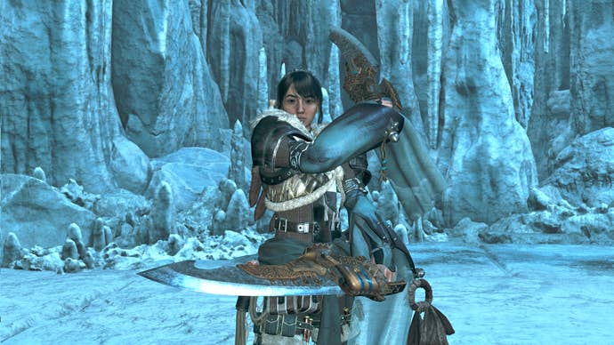 A female hunter in Monster Hunter Wilds poses in front of the camera with their weapon of choice, the Dual Blades.