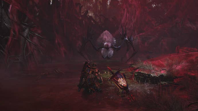 The Lala Barina, a spider monster, approaches the player menacingly in a cave of red webs.