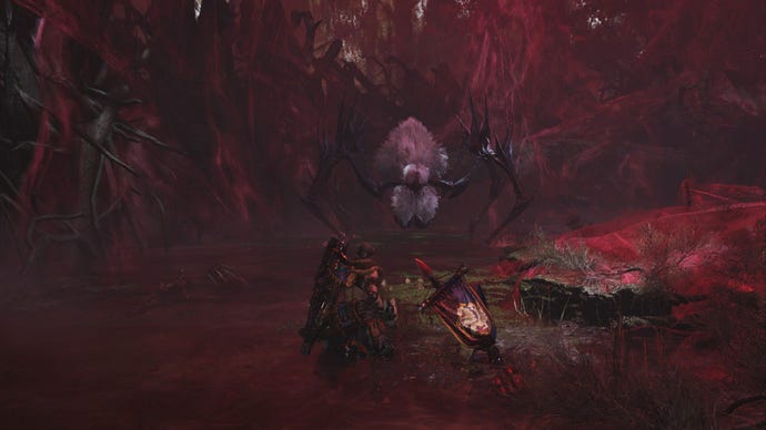 The Lala Barina, a spider monster, approaches the player menacingly in a cave of red webs.