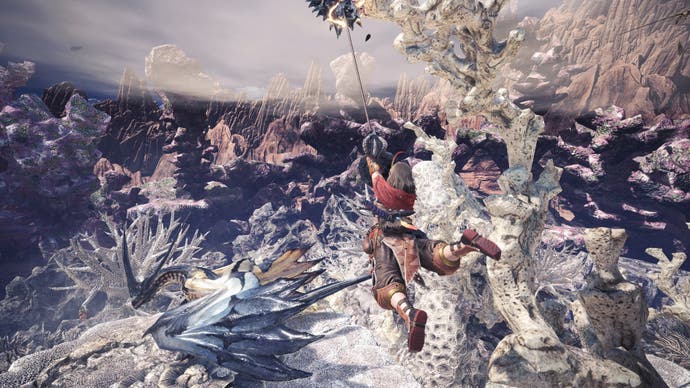 A female hunter swings through the air on a rope above a blue dragon monster in Monster Hunter World
