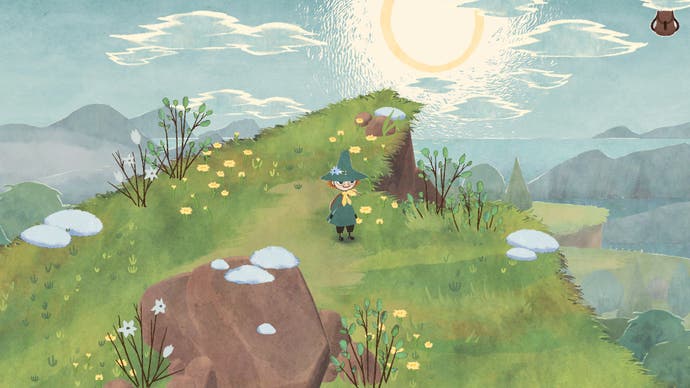 A screenshot of the game Snufkin: Melody of Moominvalley showing an idyllic isometric countryside scene, in which the small character Snufkin stands near the precipice of a cliff that seems to reach up into a low spring sun as flowers blossom around him.