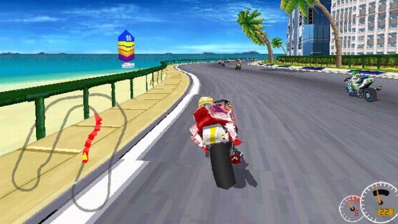 An image from Moto Racer which shows the player racing a motorcycle along a coastal road, with the sea on the left, and palm trees to the right.