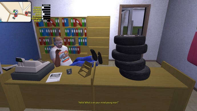 A repair man sits with his feet up in an office with a pile of tires on the desk.