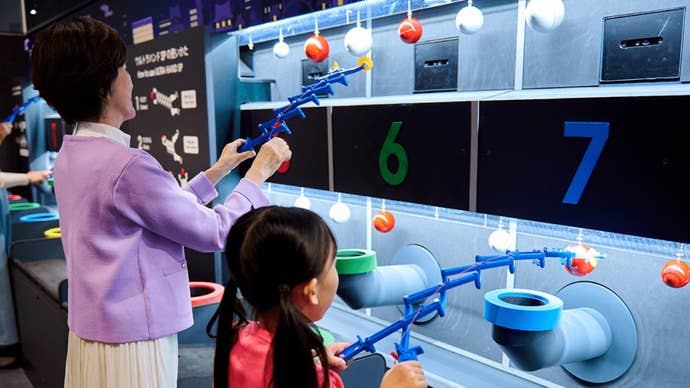 Nintendo Museum visitors playing a grabbing game inspired by Nintendo’s classic Ultra Hand toy.