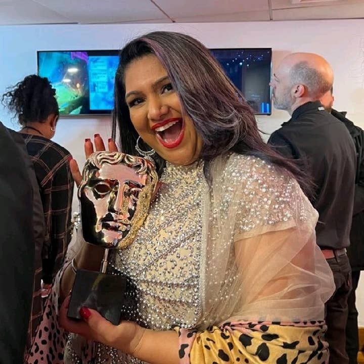 Roll7's Nisha Minhas, posing with a BAFTA award and smiling