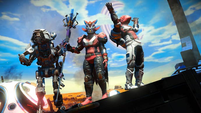 Three No Man’s Sky player characters stood next to each other, a blue sky covering the horizon.
