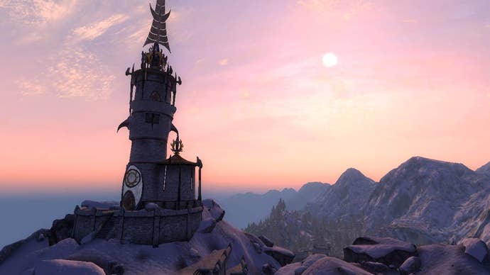 A tower sits atop a mountain in The Elder Scrolls IV: Oblivion, with the sun setting in the distance.