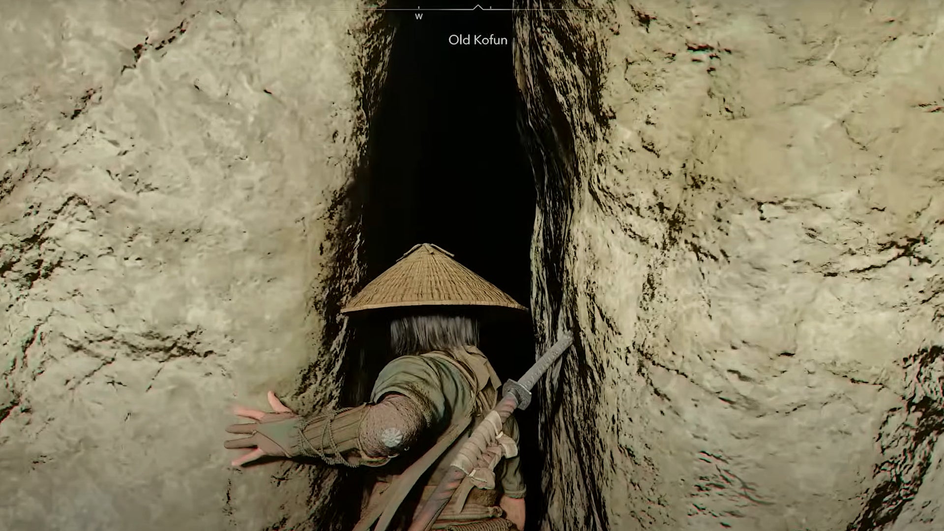 Naoe stands in front of a giant rift in a rock wall that leads to the Old Kofun in Assassin's Creed Shadows. - 1