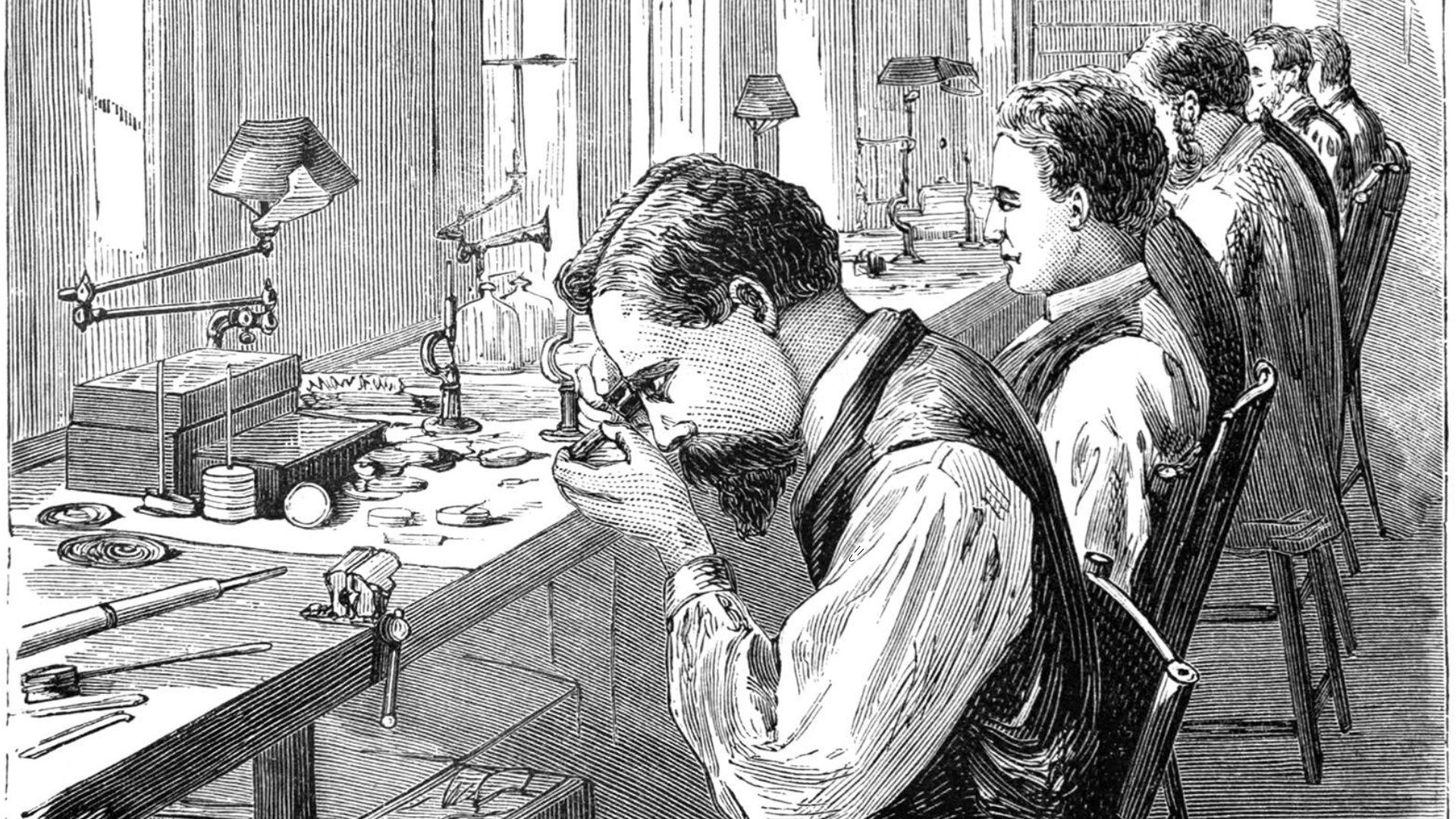 An old black and white illustration of the workshop of a watch factory where men are busy at work, sitting on chairs lining the workbench. - 1