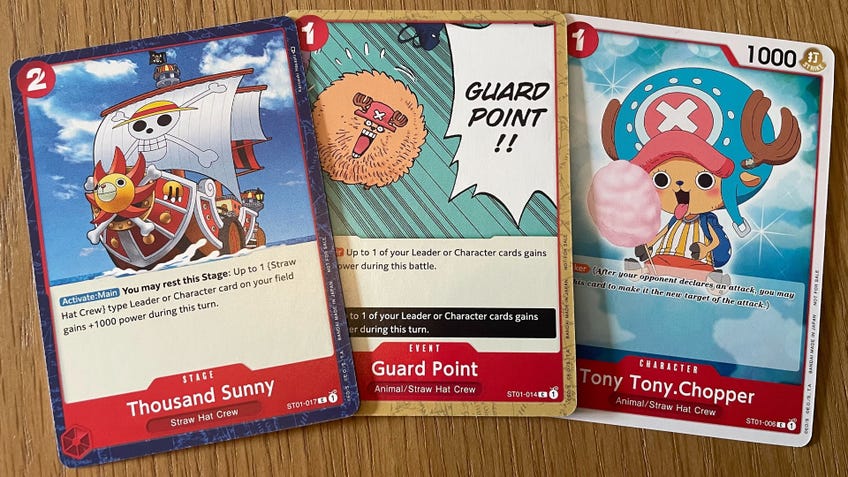 Three different card types from the One Piece Card Game: a stage (Thousand Sunny), event (Guard Point) and character (Tony Tony Chopper)