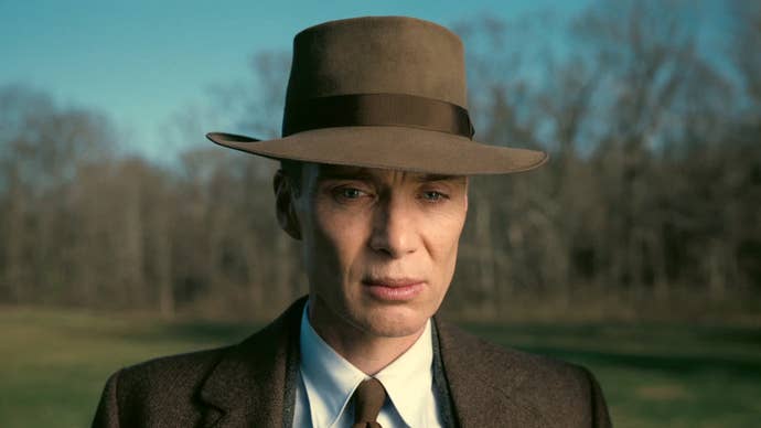 Cillian Murphy as J. Robert Oppenheimer in Oppenheimer, he’s in a park, looking solemnly down at something.