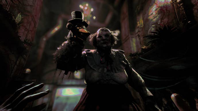 Screenshot from The Outlast Trials showing a menacing woman in a twisted mask approaching the camera while holding a creepy sock puppet aloft on one arm.