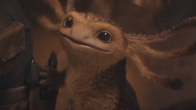 Vix, a small axolotl-like alien from Star Wars: Outlaws, looks up at the camera curiously.