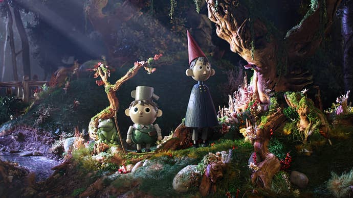 Greg, a young boy wearing a kettle for a hat, and Wirt, a teen with a blue clock and point red hat, are stood in a forest in a stop-motion style in Over the Garden Wall.