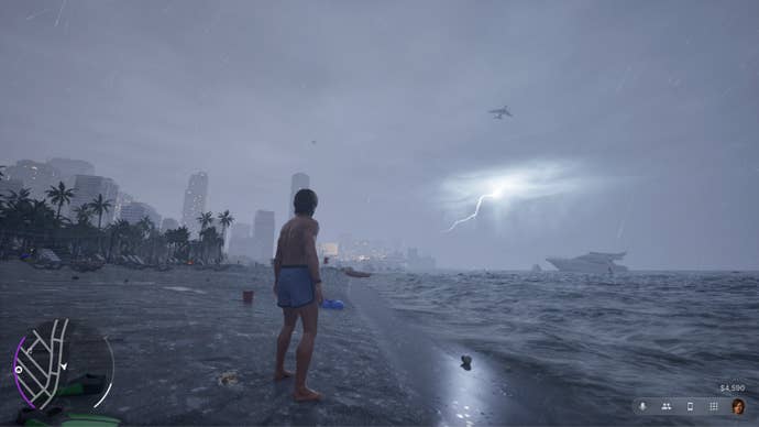 The player stands on a beach in stormy weather, wearing only swim shorts.