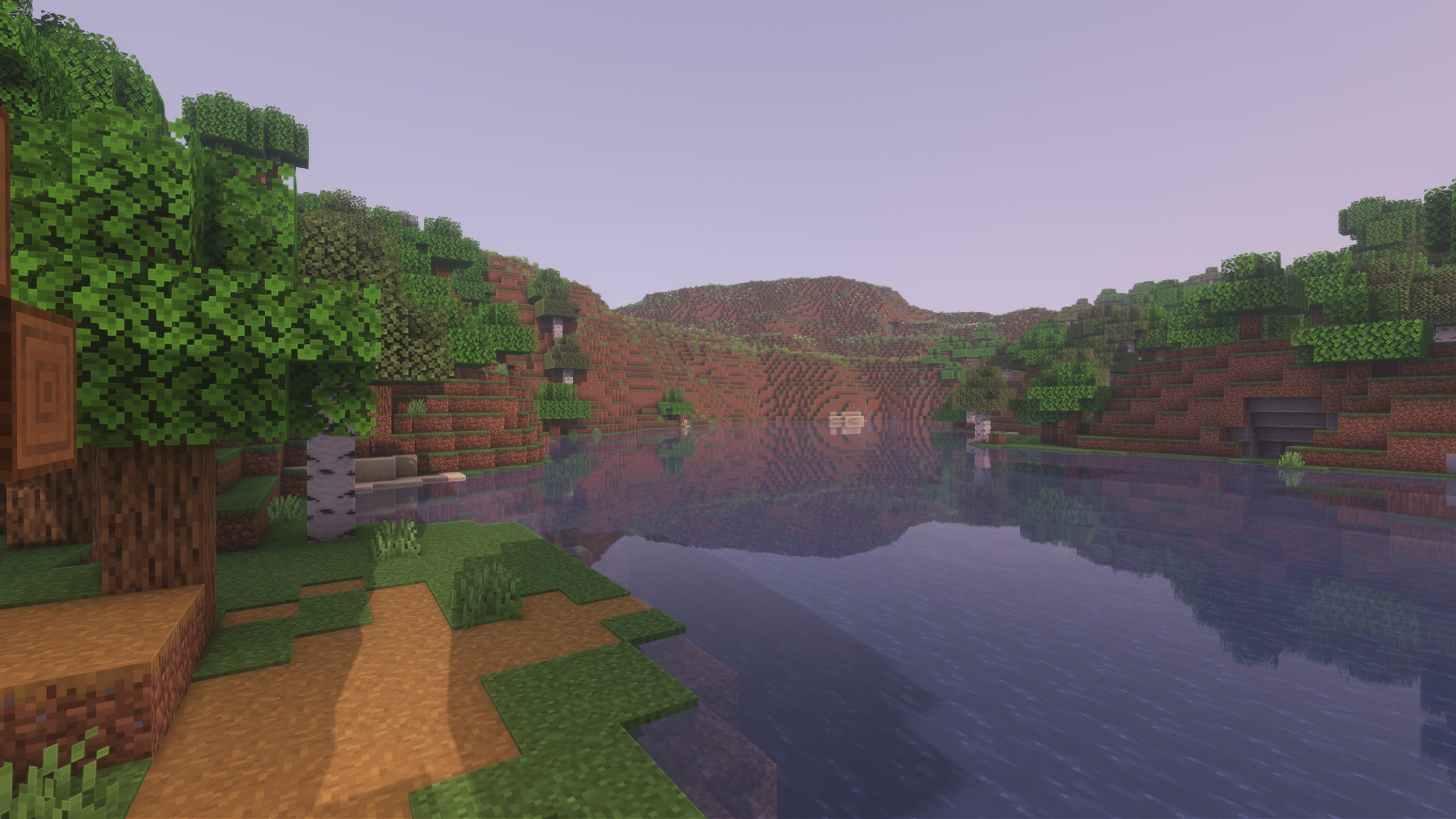 A screenshot of a river in Minecraft, with some trees on either side of the bank and a hill in the distance, taken using Pastel shaders.