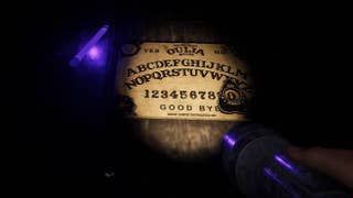 An Ouija board in the dark, lit by torchlight.