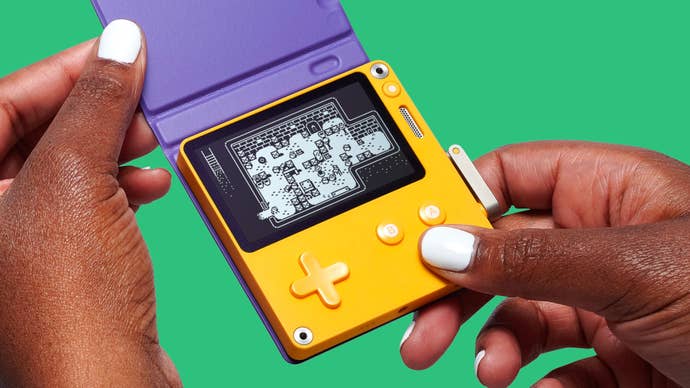 Promotional art showing a pair of hands holding a Playdate handheld gaming console.