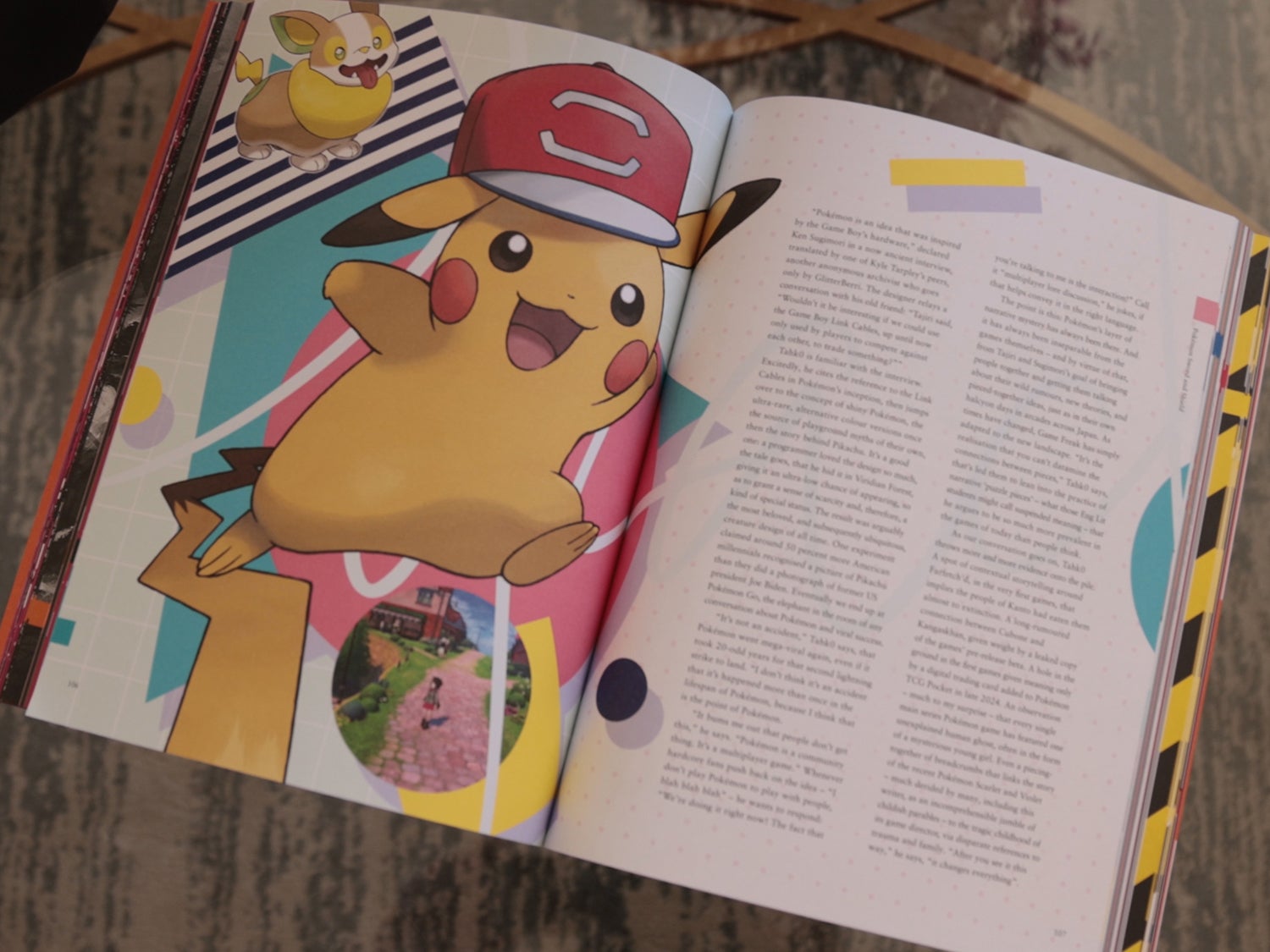 A photo of the coffee table journal ON Games Vol 2 on a table showing it open to a page with Pikachu with a hat