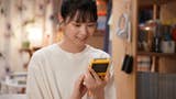 Promotional shot for Pokétsume with main character Madoka Akagi smiling at a yellow Game Boy