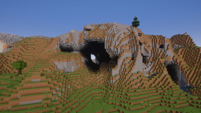 An extreme hills biome in Minecraft with a cave cutting through the hill.
