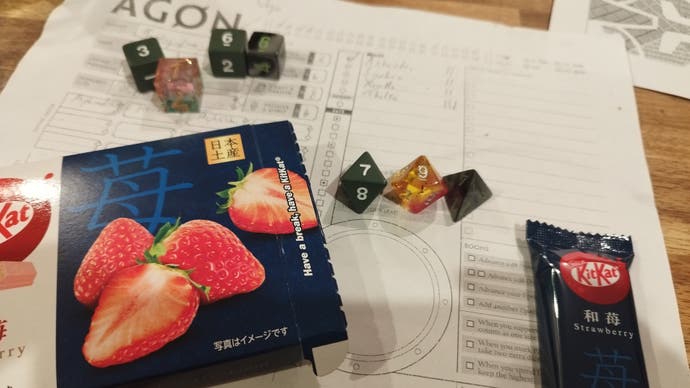 A photo of dice and snacks resting on a tabletop RPG character sheet.