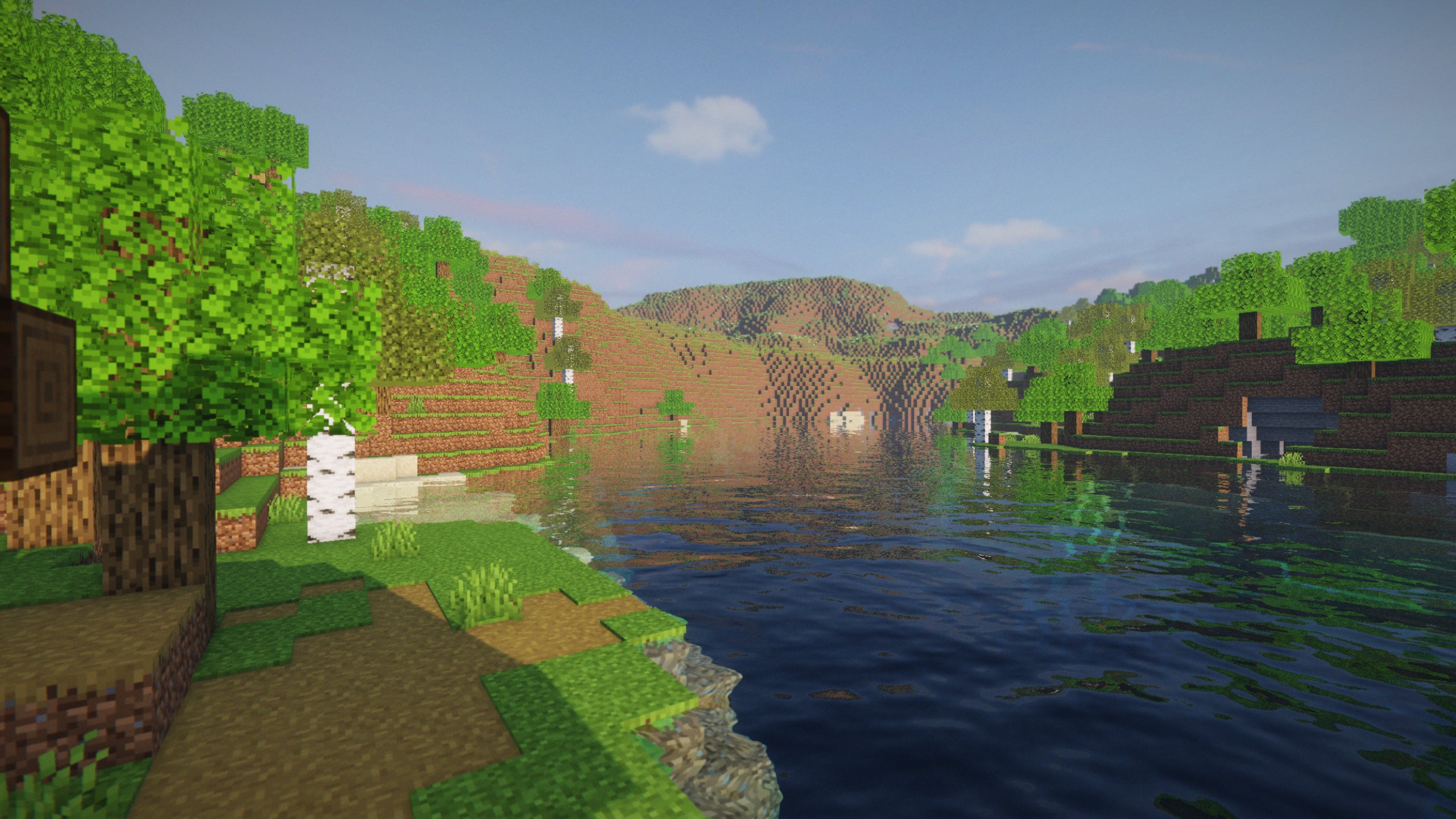 A screenshot of a river in Minecraft, with some trees on either side of the bank and a hill in the distance, taken using ProjectLUMA shaders.