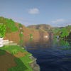 A screenshot of a river in Minecraft, with some trees on either side of the bank and a hill in the distance, taken using ProjectLUMA shaders.