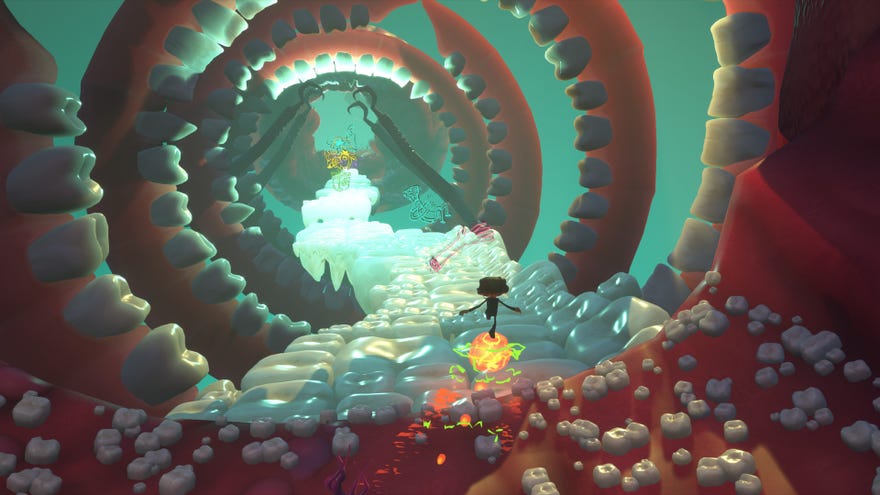 Raz rolls through a horrible level of teeth and gums and tongues in a Psychonauts 2 screenshot.