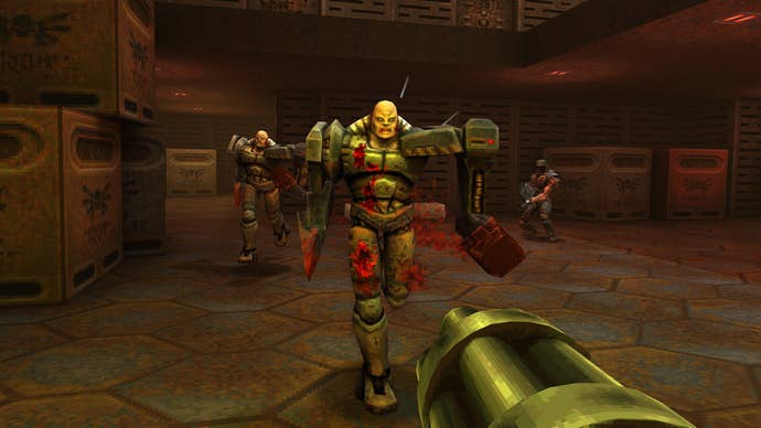 Quake 2 screenshot showing first-person view of player aiming machine gun at a charging robot with bald head