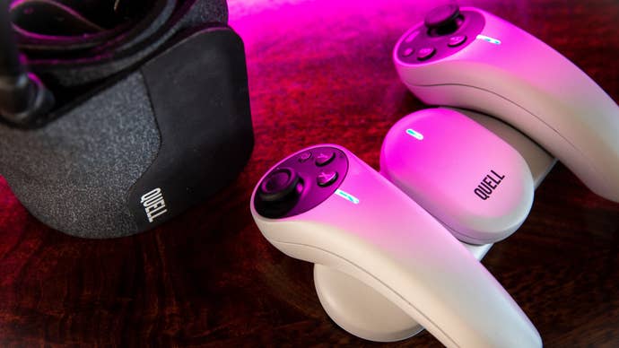 A close-up product shot of the Quell fitness equipment. It comprises two handheld controllers with a thumbstick and face buttons on, one sensor device, a charging dock for all of them, and then a neoprene belt that fixes around your midriff. Not pictured: resistance bands that can toughen the workout.