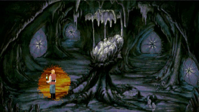A man holds a torch in a twisty dark cave in Quest For Glory 4.
