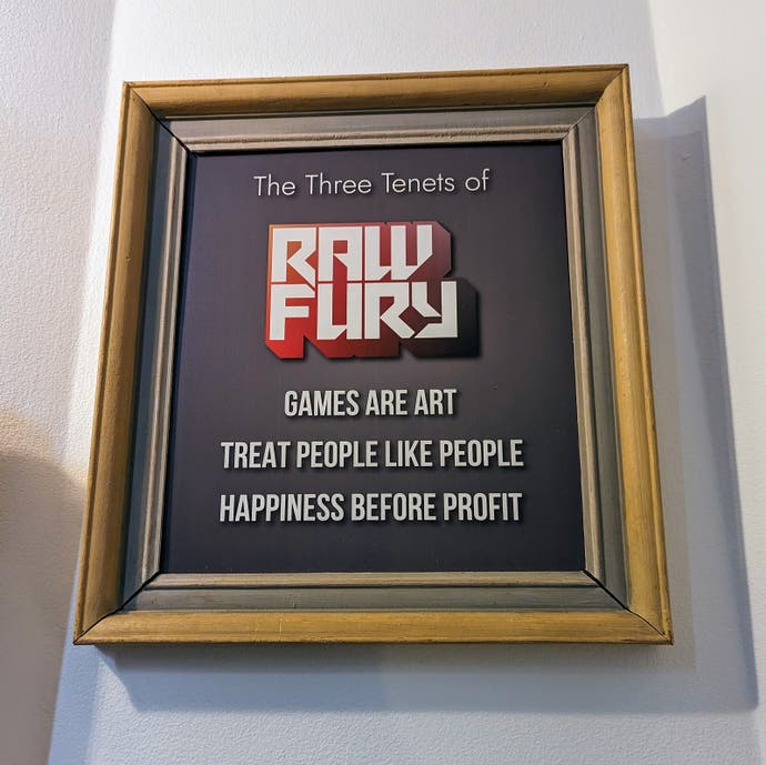 A photograph showing a framed poster on a wall that depicts Raw Fury's three tenets.  They are: Games are art, treat people like people, and happiness before profit.