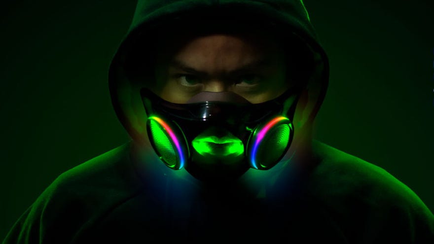 A man in a hood wearing Razer’s Project Hazel face mask, and his face is illuminated by its interior RGB lighting