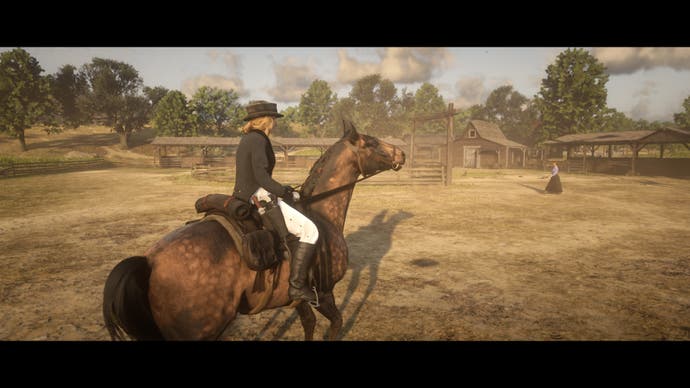 A lady in dressage wear riding a horse in a dusty, arid landscape. Another lady looks on, possibly in the horse's way, which could be ugly.