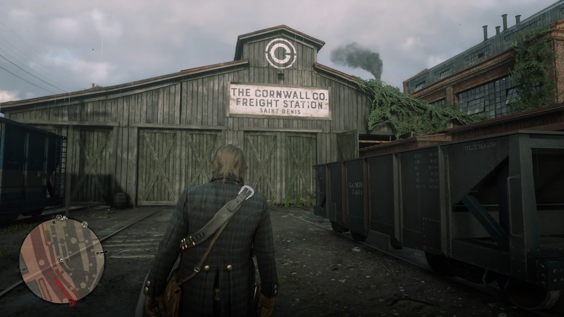 Arthur Morgan approaching the Cornwall Freight Station building in Red Dead Redemption 2. - 1