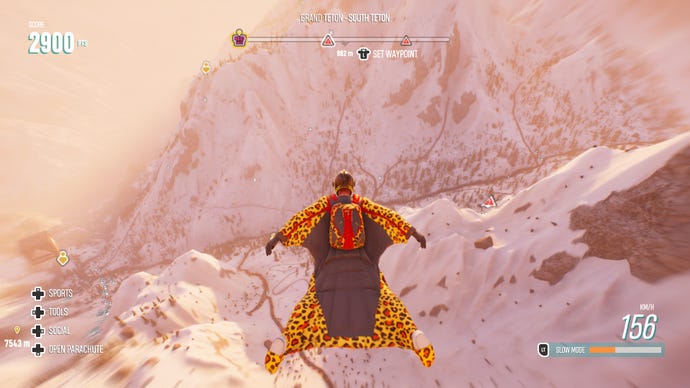 A man flies down a snowy mountain in a leopard print wingsuit in Riders Republic