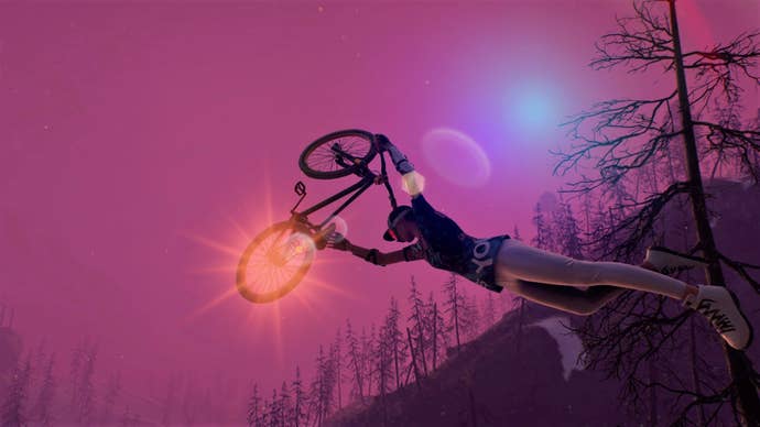 A bike held aloft above a rider’s head, with burnt, bare trees providing the horizon for an otherworldly purple sky.