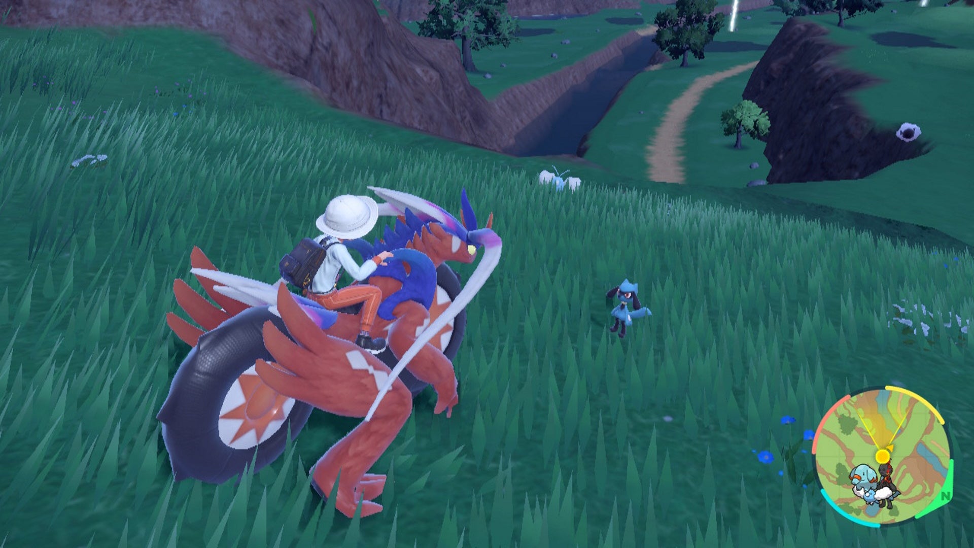How to get Riolu in Scarlet and Violet: An anime child sitting on a large red lizard in a field is looking at a small blue and black creature with floppy ears - 4